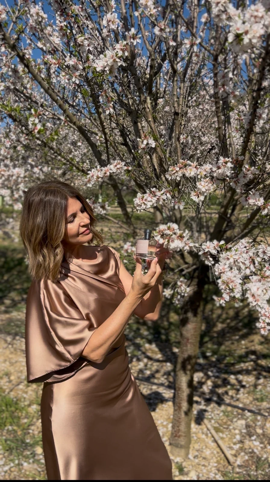 Ana Arasanz presentando su fragancia entre árboles en flor